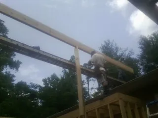 Carpenter setting a ridge beam over a new addition frame — Ice Dam Removal by Roofing Brothers in Tiltonsville