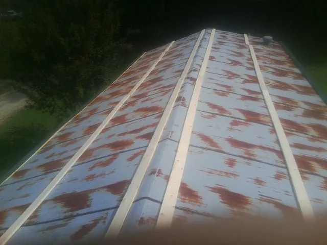Rusted metal roof panels with new wood purlins before replacement — Storm Damage Roof Repair in Tiltonsville by Roofing Brothers
