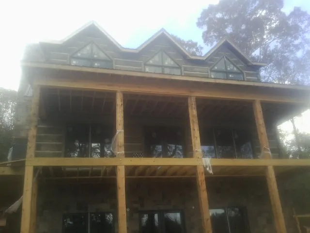 Dormers and porch framing on a large log home under construction — Roof Coating work by our crew in Tiltonsville
