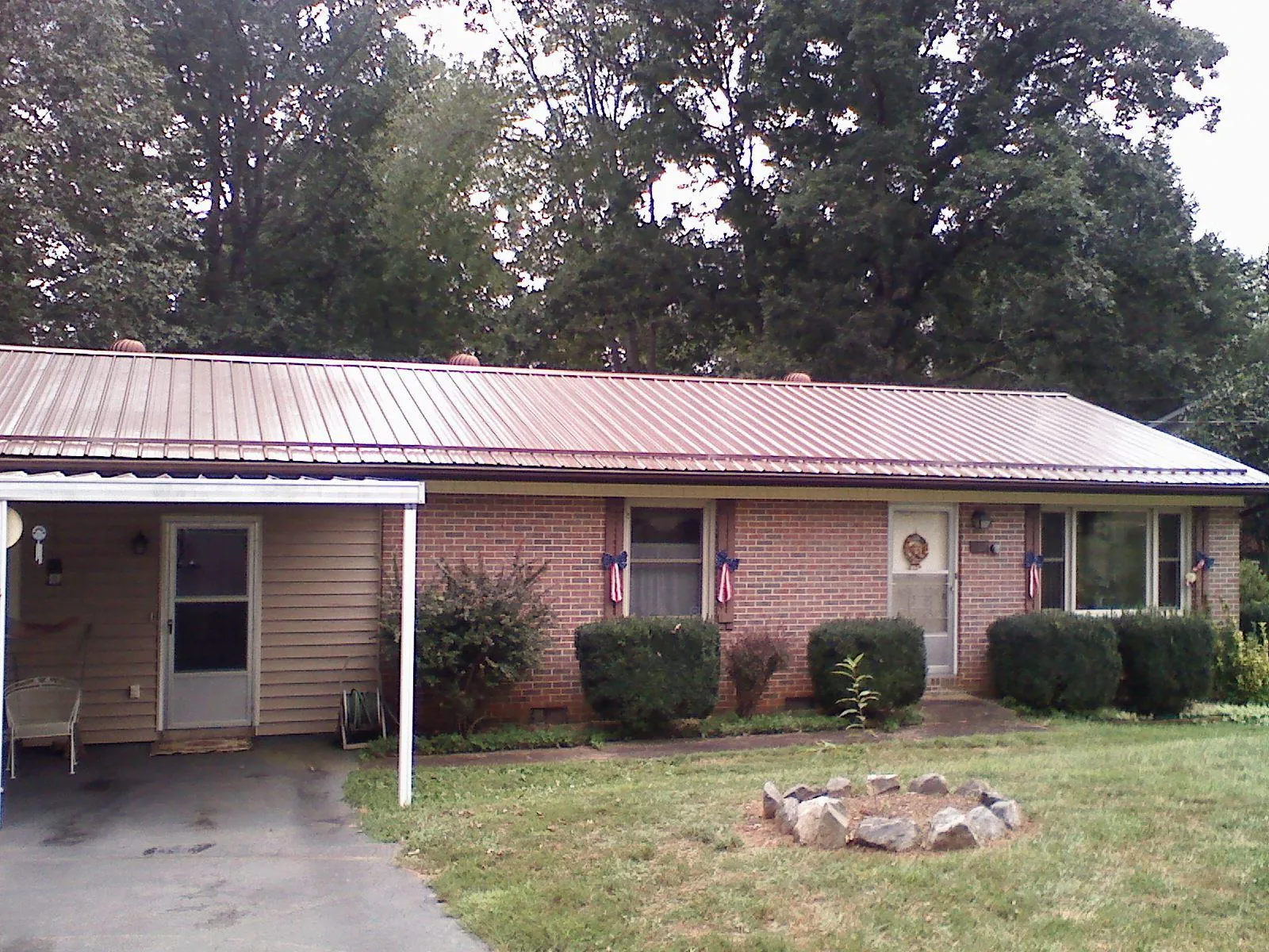 Bronze metal roof and carport on a brick ranch home — Roof Repair work by our crew in Tiltonsville